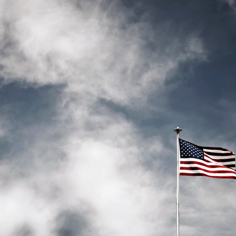 waving USA flag under grey sky